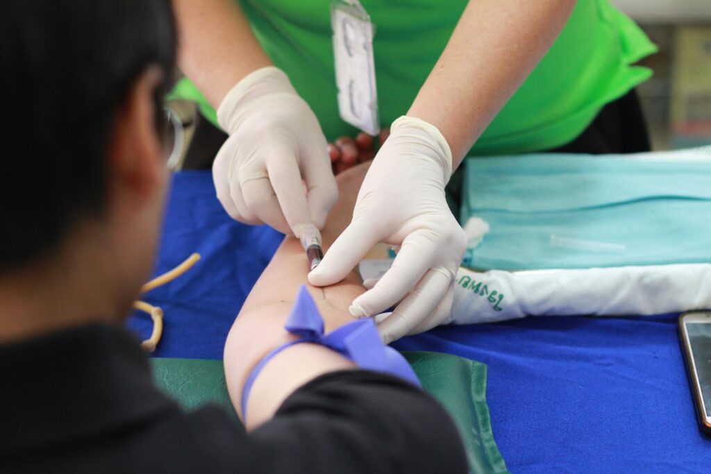 A healthcare professional administering an injection to a patient's arm during a medical procedure.